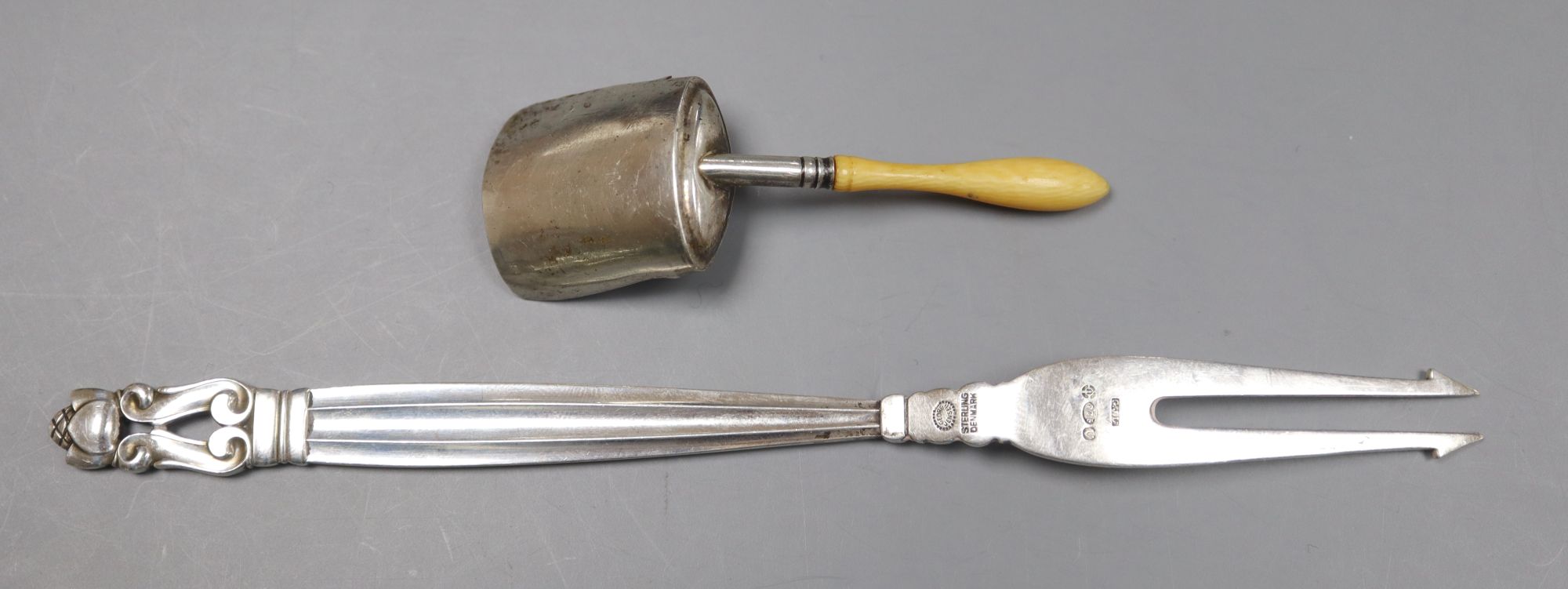 A 1950s Georg Jensen sterling pickle fork and a George III ivory handled silver caddy spoon.